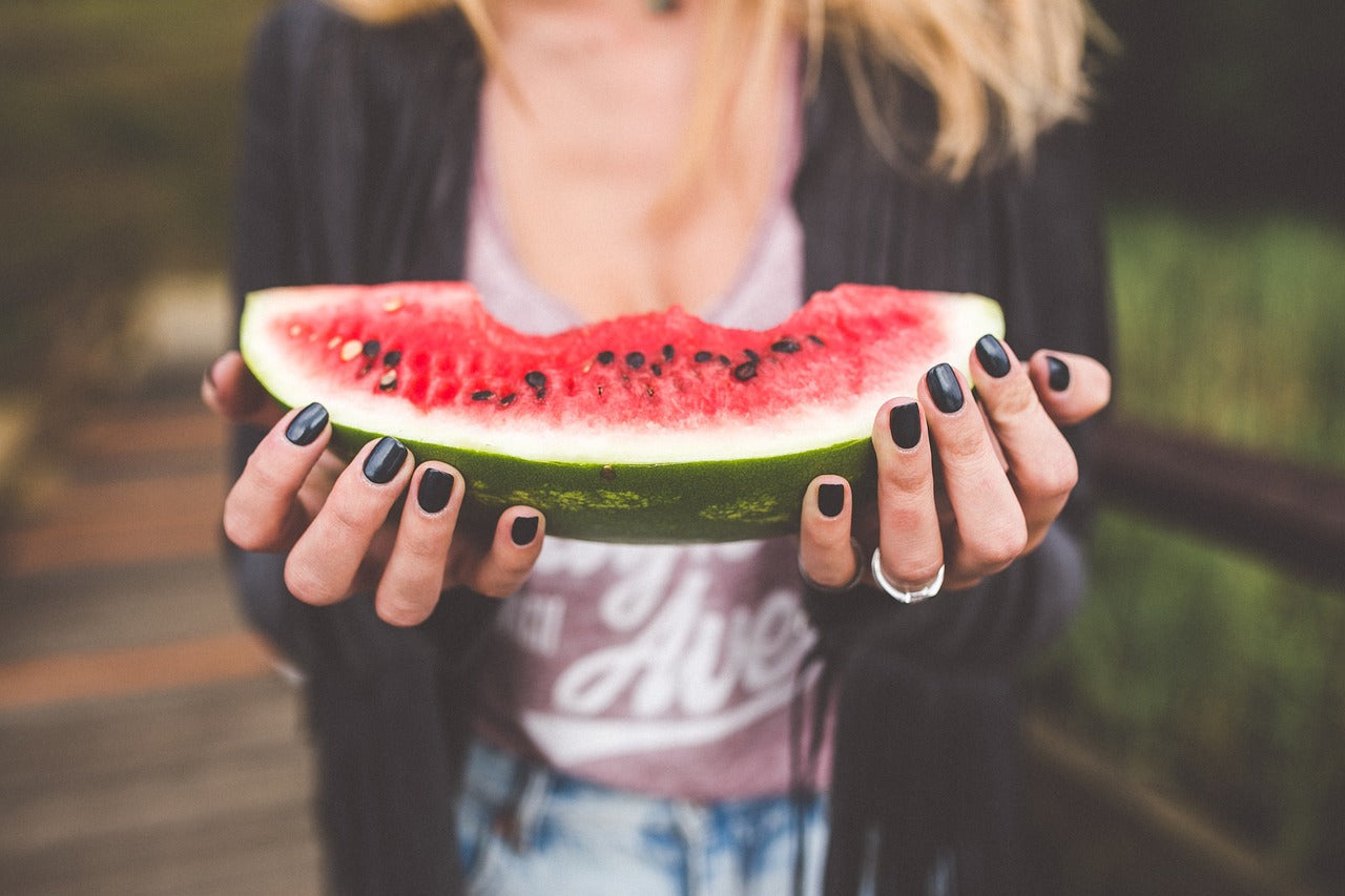 Woman holding bitten watermelon slice