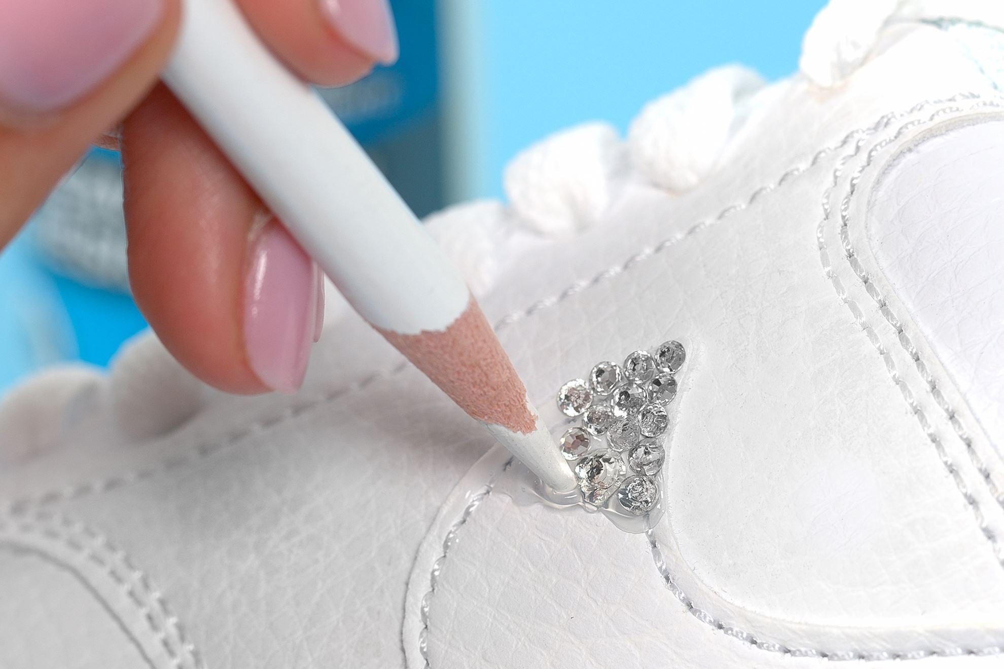 Press rhinestone into glue