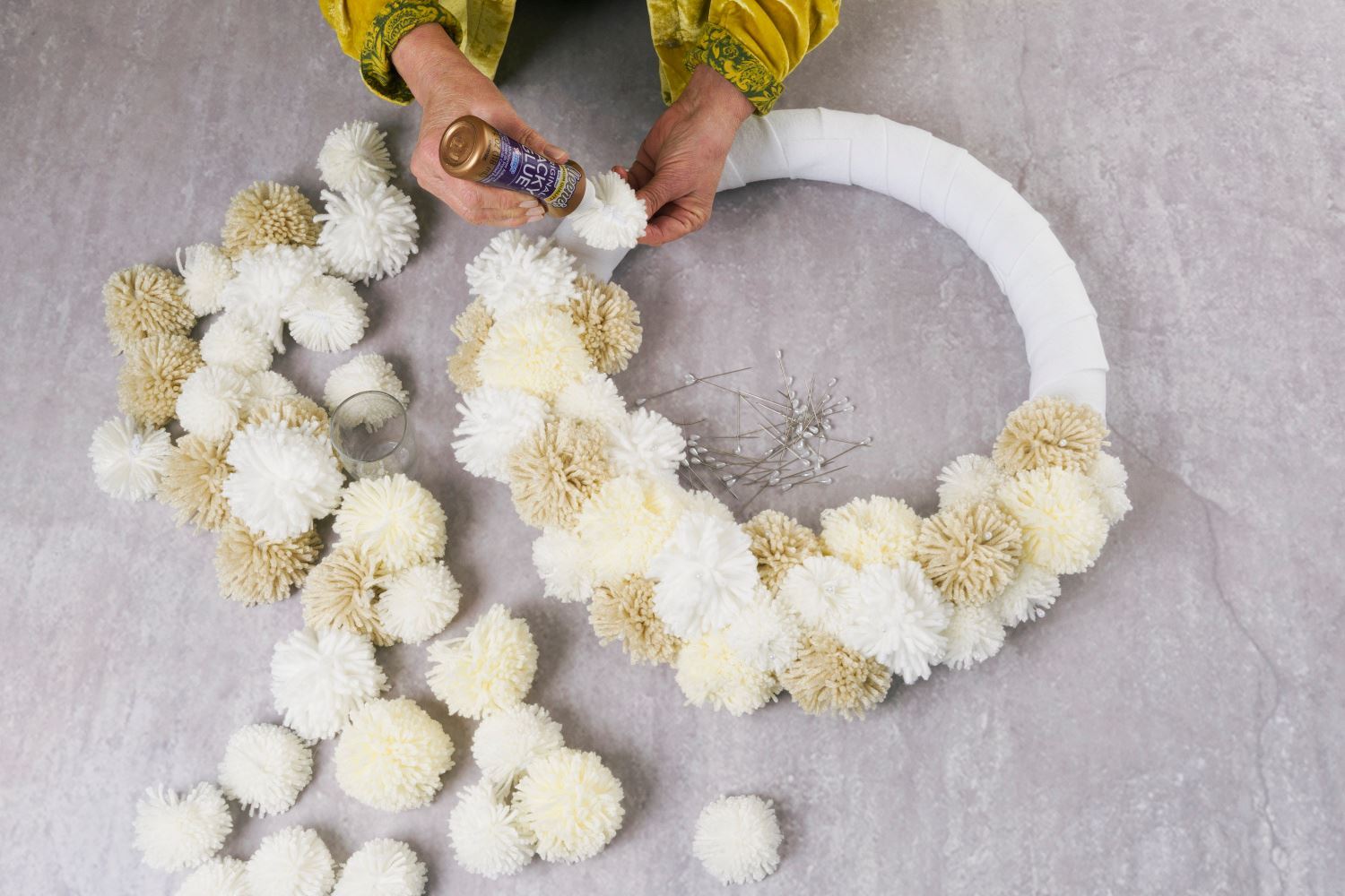 Use Tacky Glue to adhere the pom poms to the wreath