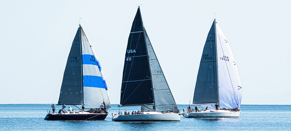 Three boats racing with spinnakers in light breeze on the great lakes.