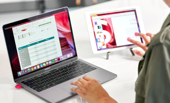 woman using a macbook and ipad