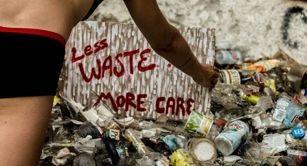 A poster on a waste island calls for less waste and more care for the planet.