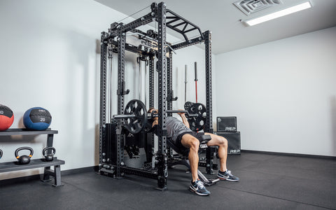 Man doing incline bench inside the power rack with the Ares 2.0