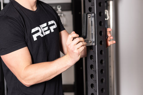 Man adjusting power rack