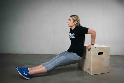 Woman doing dips on a plyo box