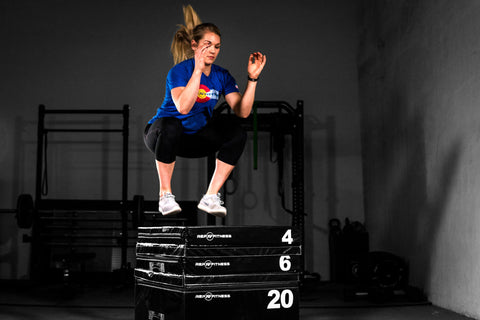 Woman doing box jumps on a plyo box