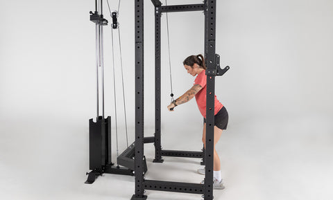 Woman doing standing pressdowns on a cable machine