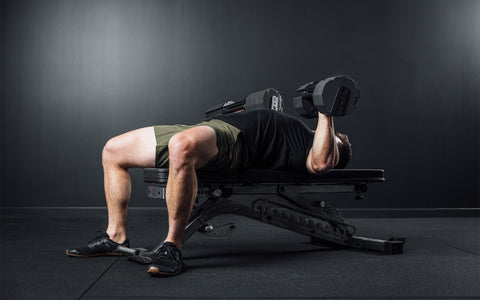 Athlete performing a bench press with a pair of REP x PÉPIN FAST Series Adjustable Dumbbells.