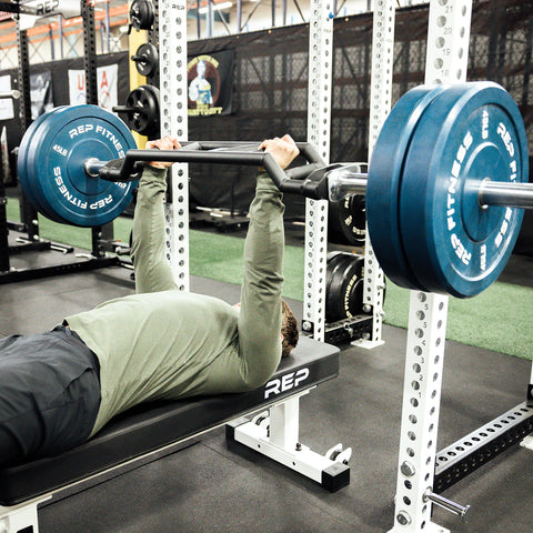Man benching with the cambered swiss bar