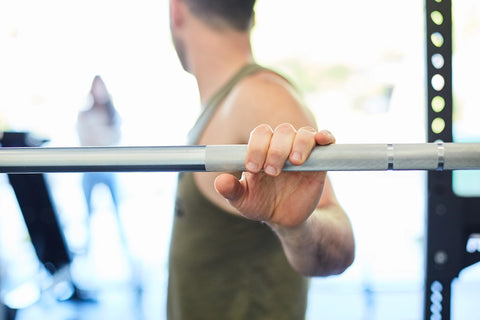 A lifter's hand on a REP barbell