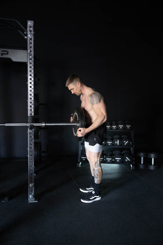 Man loading a barbell in a home gym