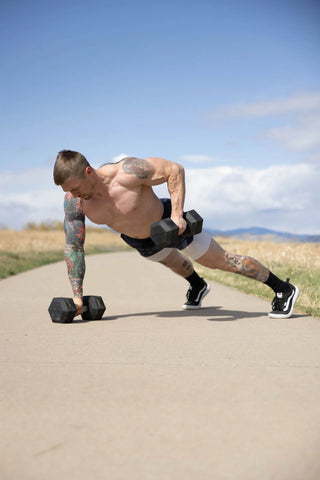 Man working out outside with dumbbells