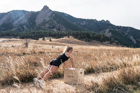 Woman doing incline push-ups on a box