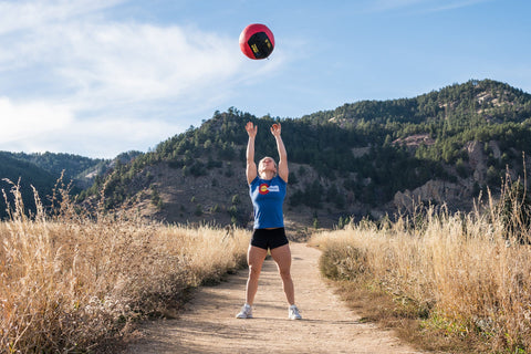 Woman working out with a medicine ball outside