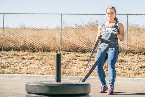 Woman doing a pull sled outside