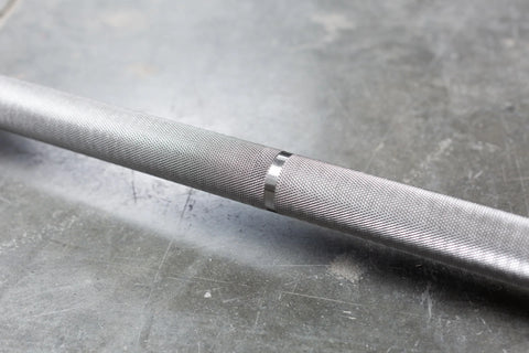 A close-up of a knurl marking on a barbell