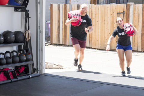 Lifters running with sandbags