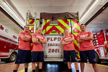 REP Employees Partnered with Firefighters Standing in Front of Fire Truck