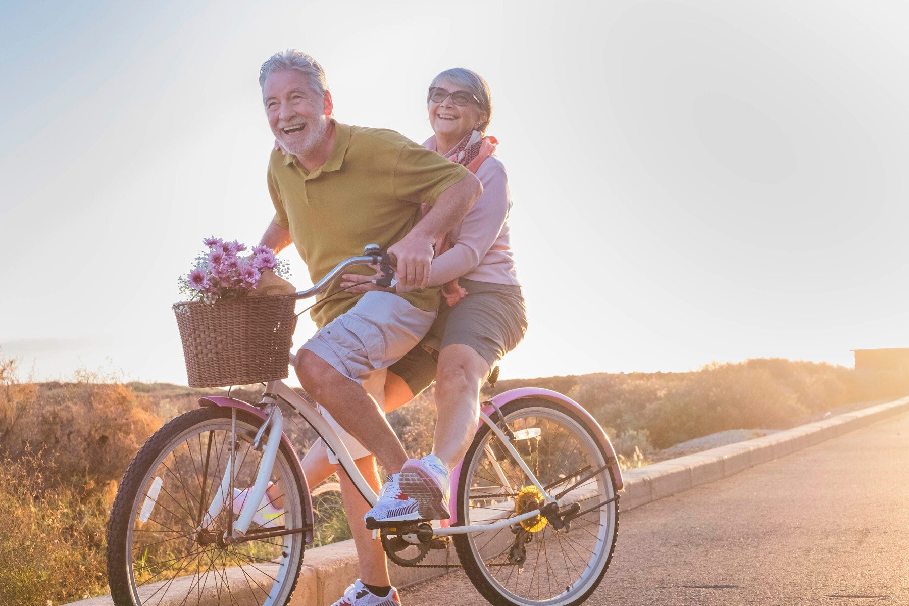 mature couple having fun on pink and white bike