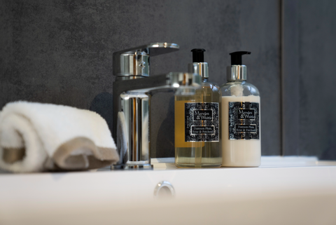 Marsden & Whittle hand wash and hand lotion bottles beside a crisp white sink with silver chrome tap.