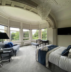 A luxurious bedroom suite inside Rainford Hall - cream carpets with crisp white ben linen. The room has views over the gardens.