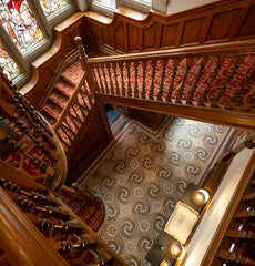 The traditional wooden staircase and marble tile floor at Rainford Hall