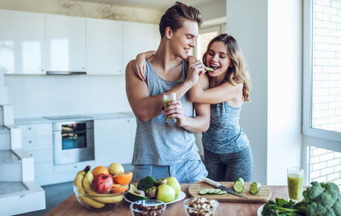 Healthy couple preparing homemade immunity shot