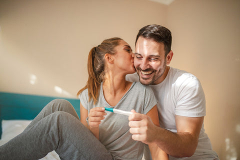 Couple feeling happy after taking a home pregnancy test.