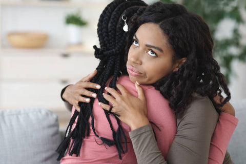 two black women engaging in a hug