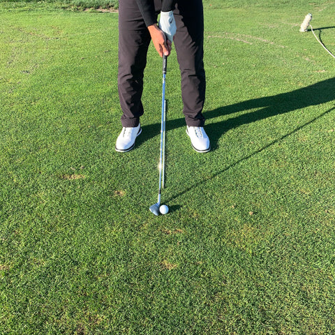 Alignment stick pointing at ball to help a player with ball position and stance width