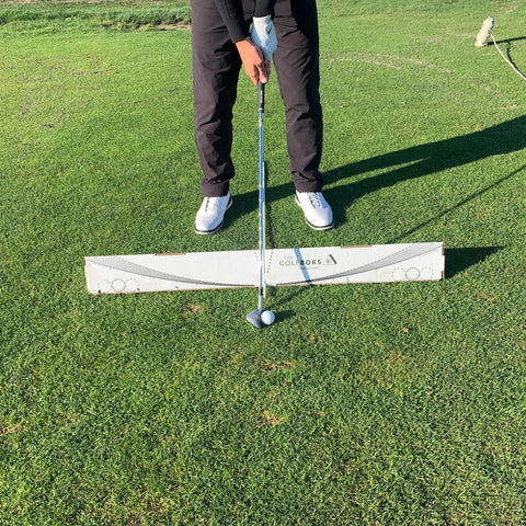 The Golf Boks being used with an alignment stick to improve setup and improve ball position, stance width, aim and alignment