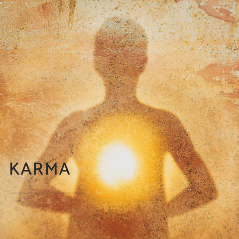 1 of 10 powerful spiritual words, karma, showing on a sandy looking image with a person holding an energy ball.