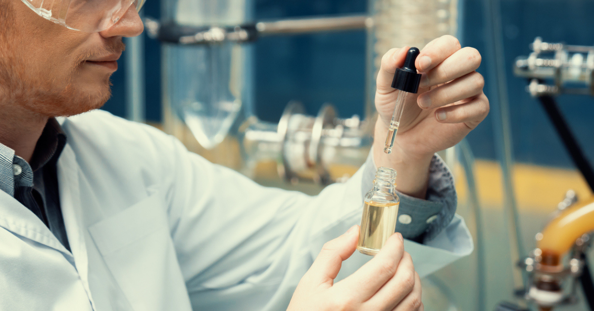 A scientist filling a viail with cannabis oil from extraction process.