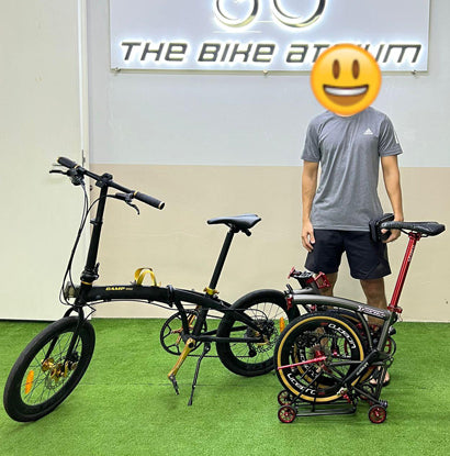 Enthusiastic customer at The Bike Atrium's trade-in event exchanging an old racer for a new touring bicycle