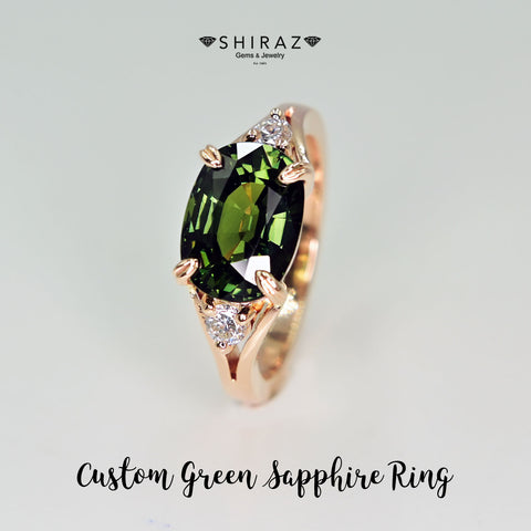 A stunning green sapphire ring set in 14k rose gold with two sparkling diamonds. The green sapphire has a vivid green color that catches the eye, and the rose gold band adds warmth and elegance to the design.