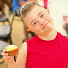 Camp Pa Qua Tuck Camper Enjoying a Cup Cake from Rocky Point Rotary