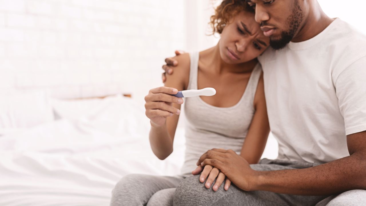 Foto de um casal a olhar um teste de gravidez