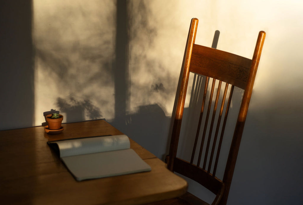 Stuhl mit Tisch und Buch in der Morgensonne