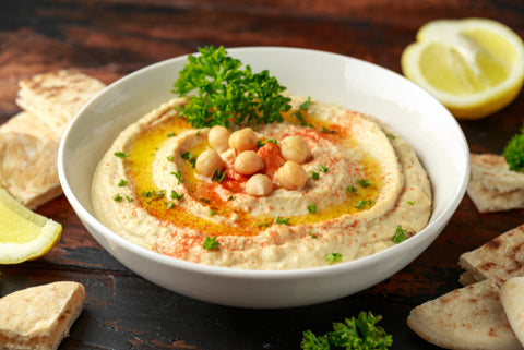 Hummus in a bowl with garnish. A vegan recipe that goes down a treat! Find out how to eat sea moss as a dip!