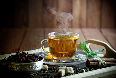 A cup of tea in a glass mug, on a wooden tray. Choose from the best sea moss recipes!