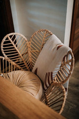 Le fauteuil en rotin et les meubles structure en bois s'accordent pour une décoration intérieure chic et relaxante