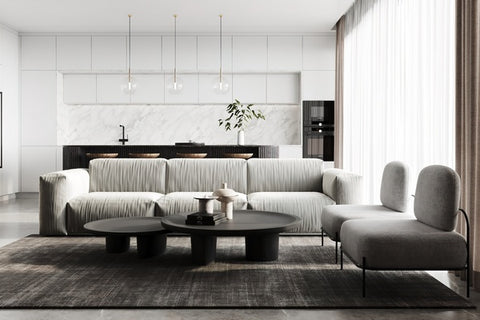 Comment créer une ambiance japandi dans le salon ou le séjour : canapé en tissu clair, fauteuils aux lignes courbes, table basse en pierre contrastée, murs blancs, luminaires éclatants