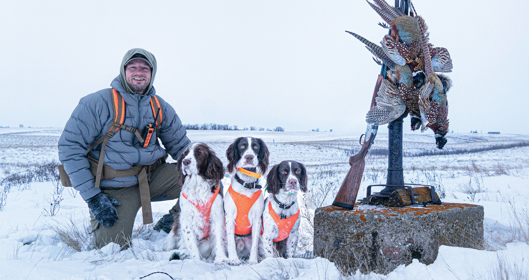 Adam Tangsrud with his three pups posing for a picture in the snow.