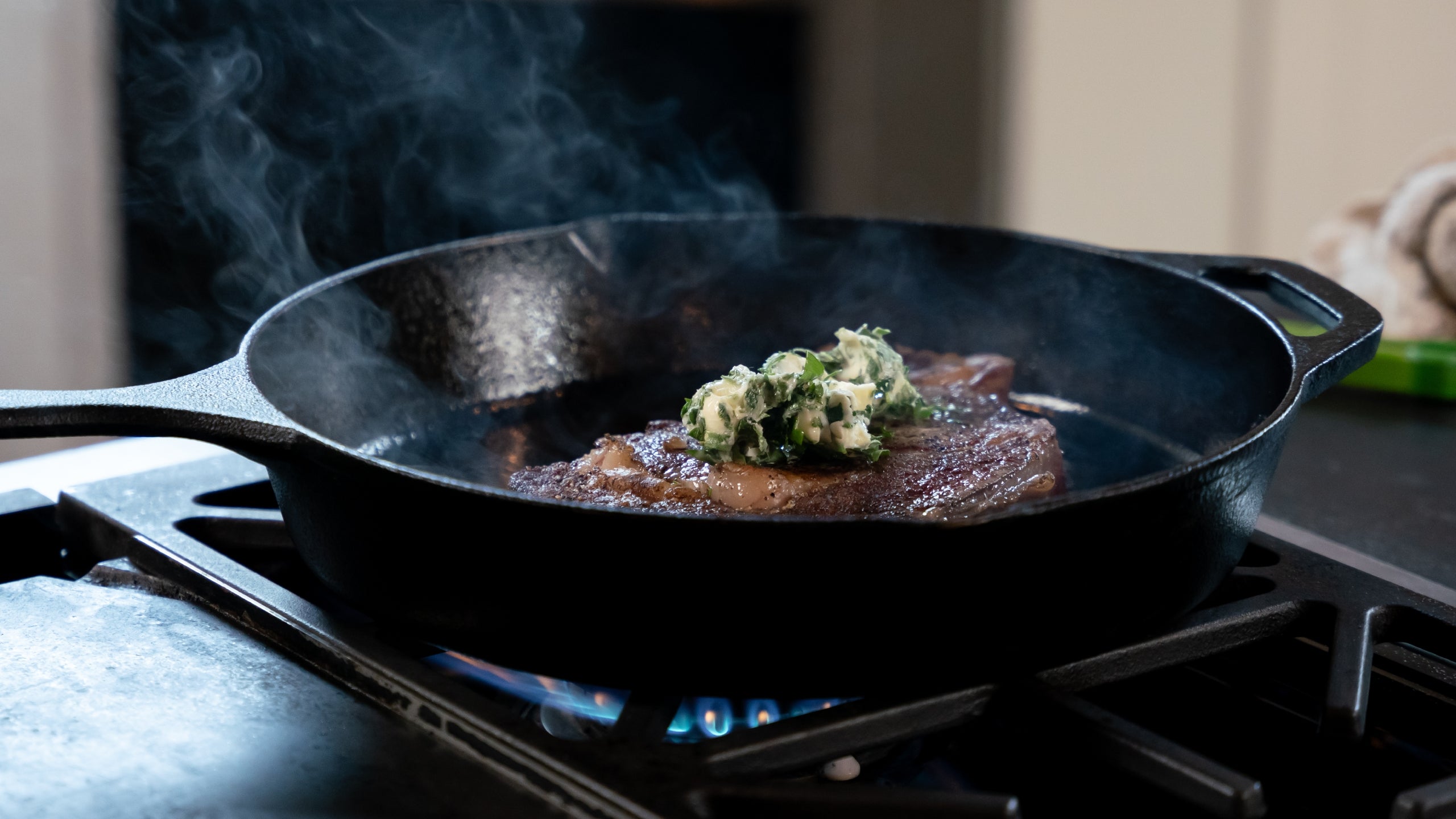 Steak cooking in a cast-iron skillet