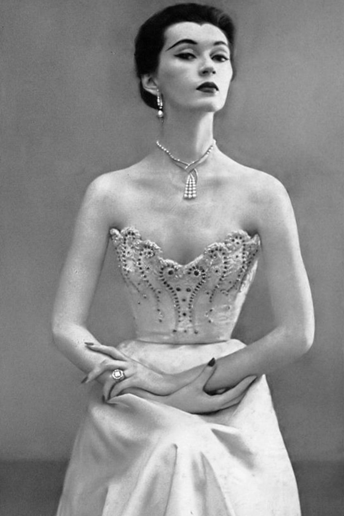 Dovima in strapless white satin dress with a tight bodice embroidered with rubies and pearls by Balenciaga, photo by Richard Avedon, Harper's Bazaar, September 1950