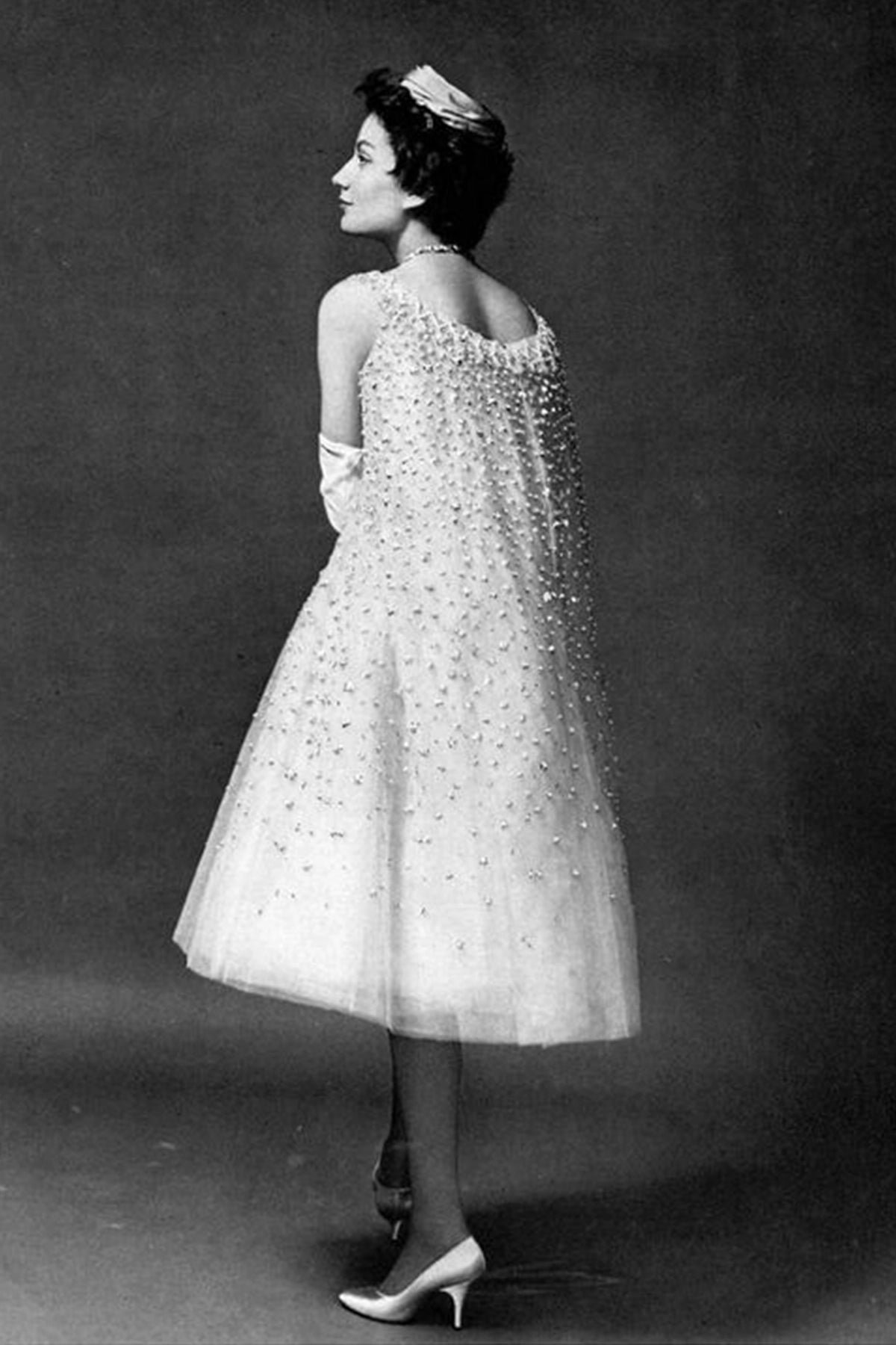 Hélène Delrieu in white silk and tulle dress embroidered with pearls by (YSL) Christian Dior, photo by Georges Saad, 1958