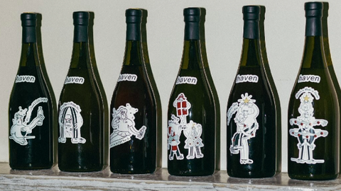 An array of decorated Haven cocktail bottles on a shelf, each with a unique illustration, indicating a quirky and personalized mixology experience.