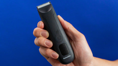 Close-up of a man's hand holding a Nateskin Bush Trimmer 2.0, emphasizing the ergonomic design and ease of use for personal grooming.