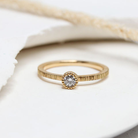 Bague de mariage en or rose ornée d'un diamant.