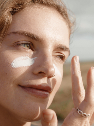 Woman Putting Sunscreen on Face